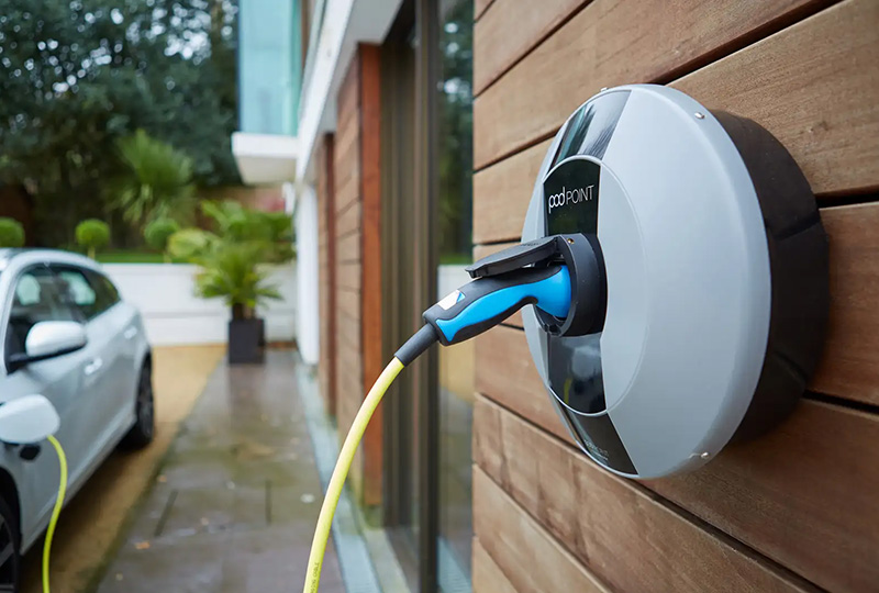 EV charger with a car in the background